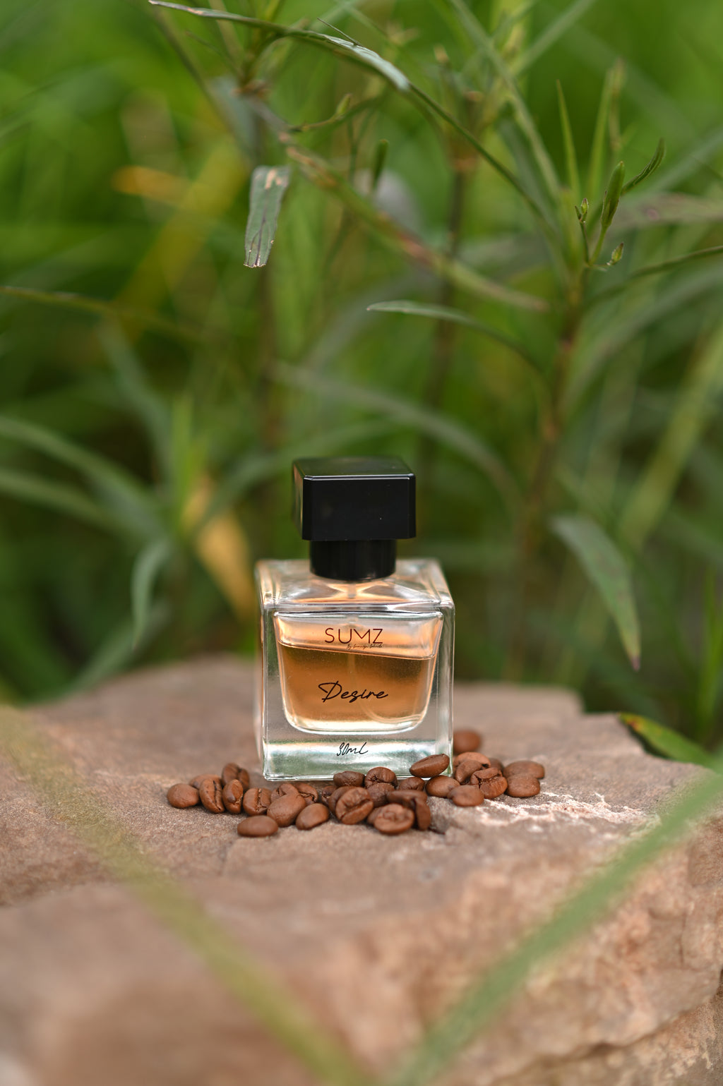 SUMZ Desire hair perfume bottle reflected in a mirror outdoors