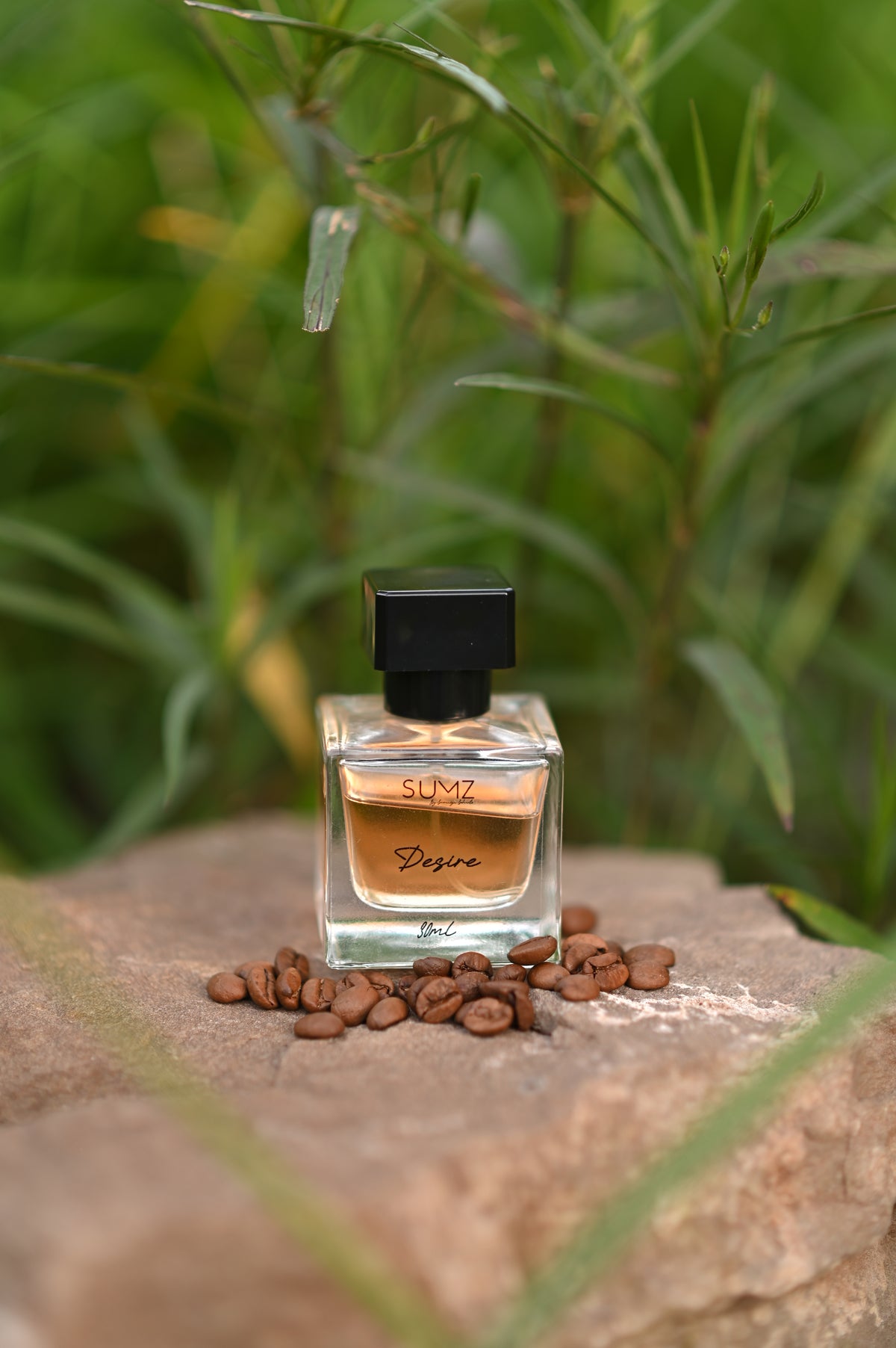 SUMZ Desire hair perfume bottle reflected in a mirror outdoors